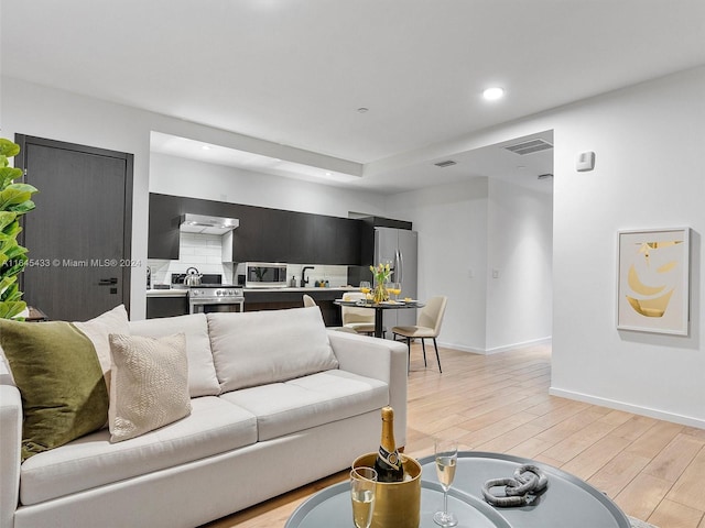 living area featuring recessed lighting, light wood-type flooring, visible vents, and baseboards