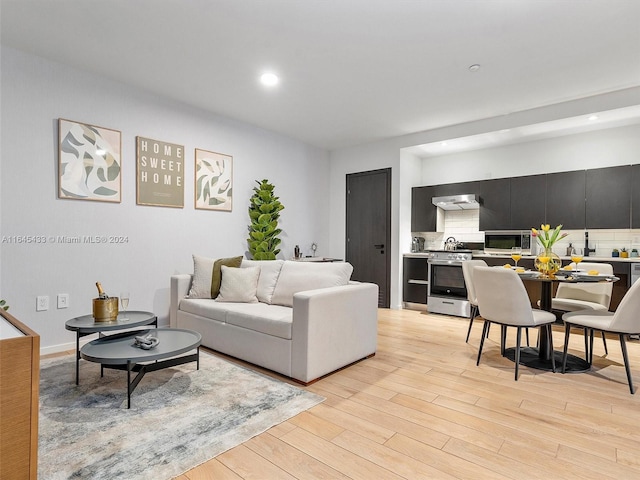 living area with recessed lighting and light wood-style floors