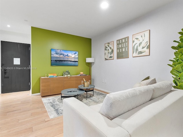 living room with recessed lighting, baseboards, and light wood finished floors