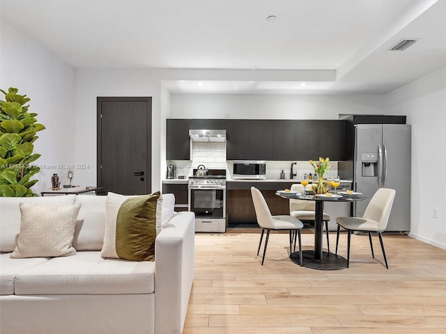 kitchen featuring appliances with stainless steel finishes, light countertops, dark cabinetry, and modern cabinets