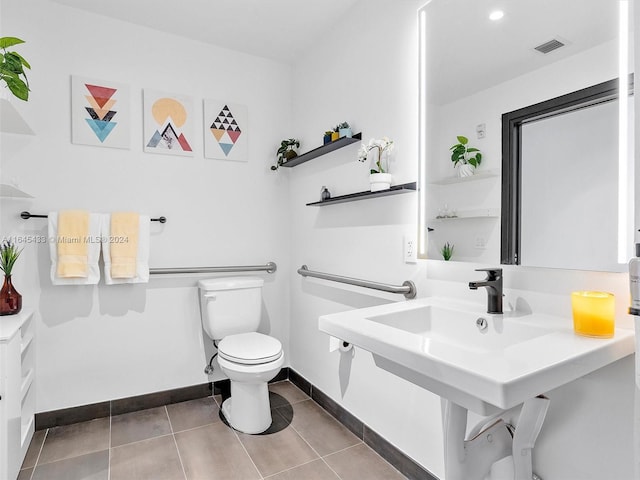 half bath featuring toilet, baseboards, visible vents, and tile patterned floors