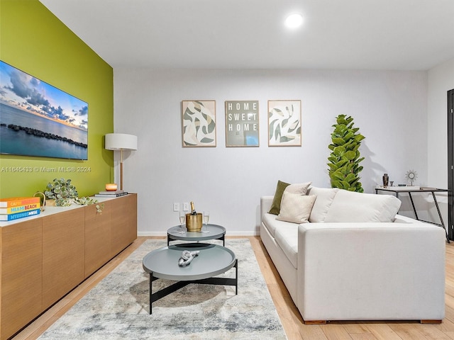 living room with light wood finished floors, baseboards, and recessed lighting