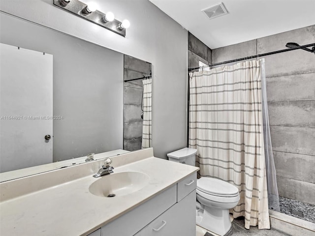 bathroom with vanity, curtained shower, and toilet