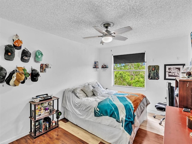 bedroom with wood-type flooring, a textured ceiling, and ceiling fan