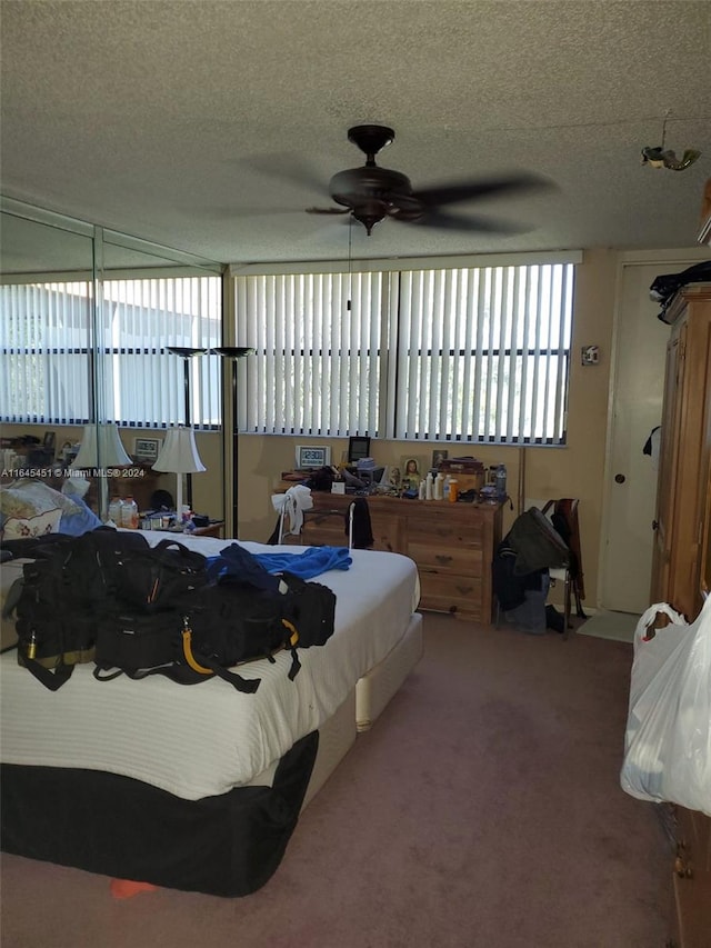 bedroom featuring ceiling fan, a textured ceiling, and carpet flooring