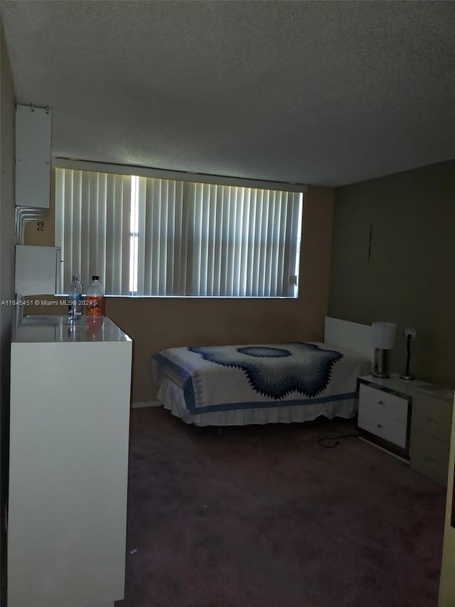 bedroom featuring carpet and a textured ceiling