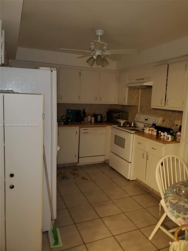 kitchen with custom range hood, white appliances, decorative backsplash, and light tile patterned floors