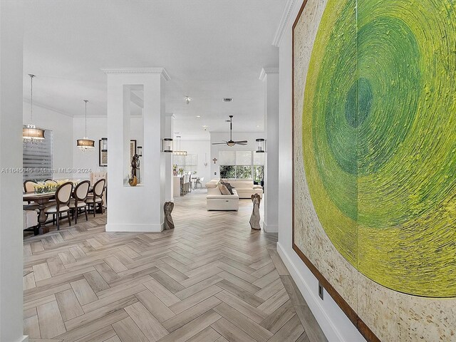 hall featuring an inviting chandelier, ornamental molding, and light parquet flooring