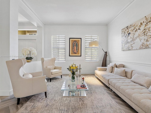 living room featuring crown molding, baseboards, and wood finished floors