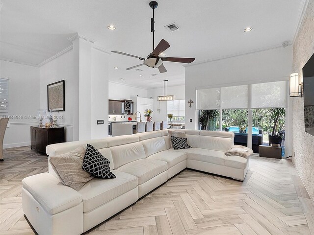 living room with sink, ceiling fan, ornamental molding, and light parquet floors