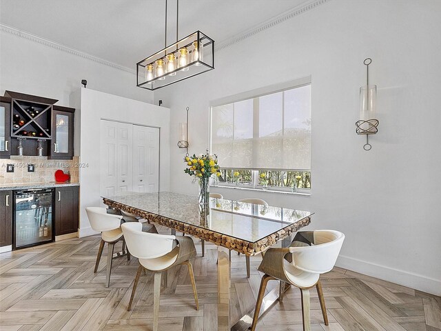 dining space with beverage cooler, ornamental molding, and light parquet floors