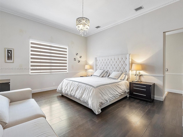 bedroom with a notable chandelier, ornamental molding, and dark hardwood / wood-style floors