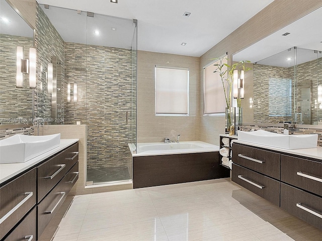 bathroom featuring plus walk in shower, tile walls, vanity, and tile patterned floors