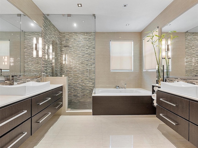 bathroom featuring tile walls, two vanities, tile patterned floors, and a sink