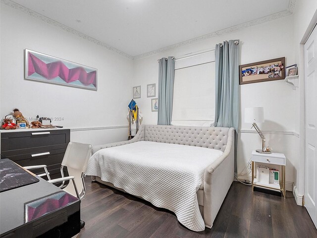 bedroom with crown molding and dark hardwood / wood-style flooring