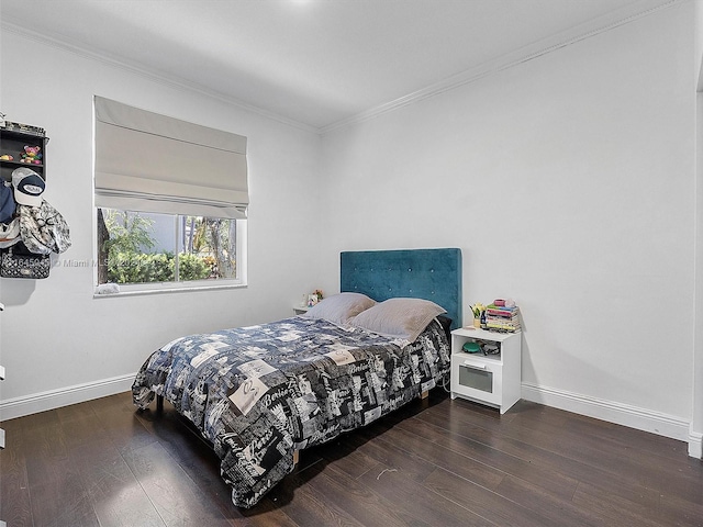 bedroom featuring crown molding, wood finished floors, and baseboards