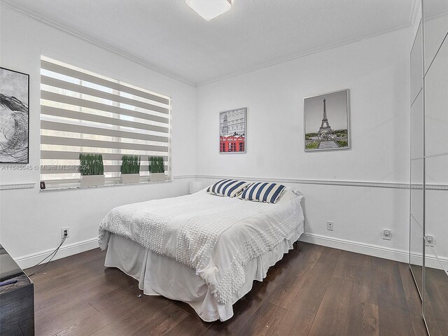 bedroom with crown molding and dark hardwood / wood-style flooring