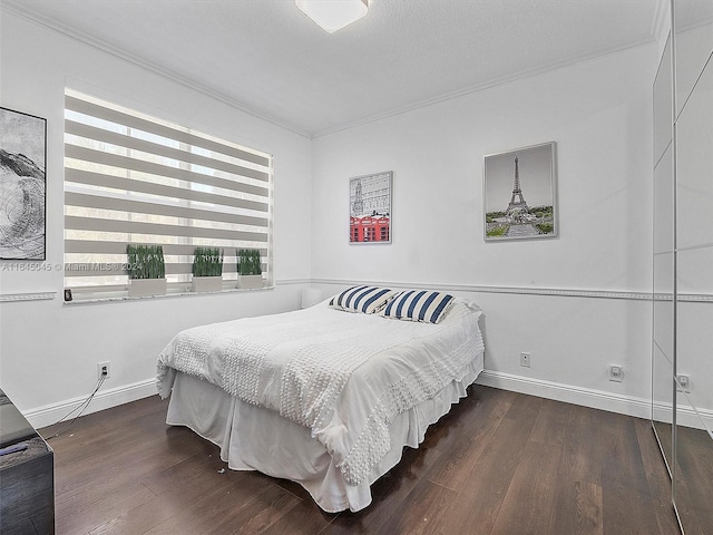 bedroom with baseboards, wood finished floors, and ornamental molding