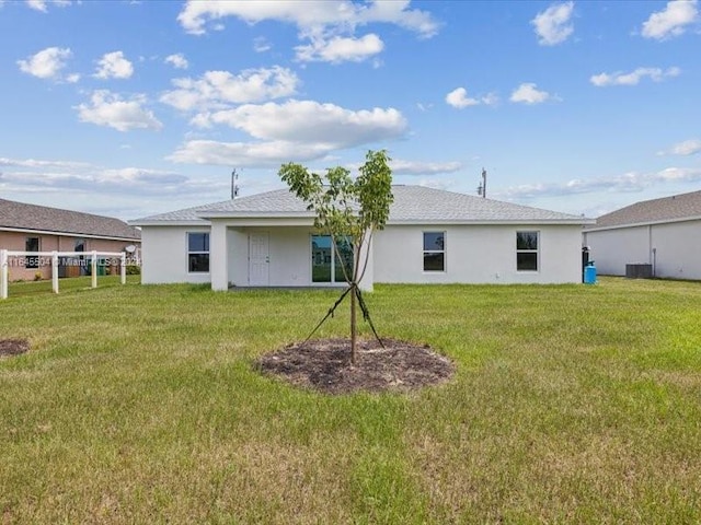 back of house featuring a lawn and central air condition unit