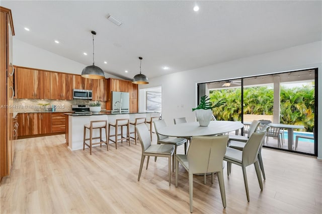 dining room with light wood-style flooring, visible vents, vaulted ceiling, and recessed lighting