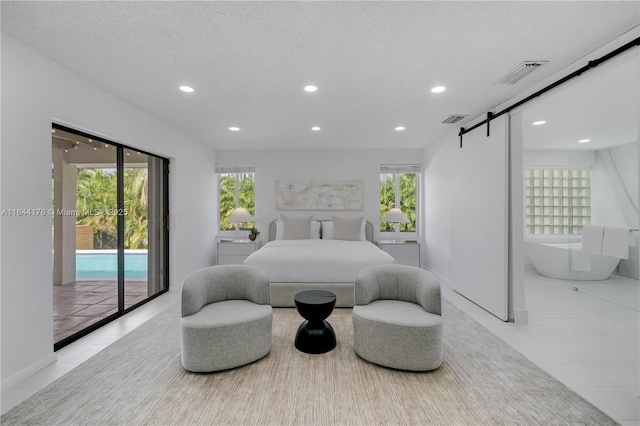 bedroom featuring access to exterior, recessed lighting, visible vents, a barn door, and a textured ceiling