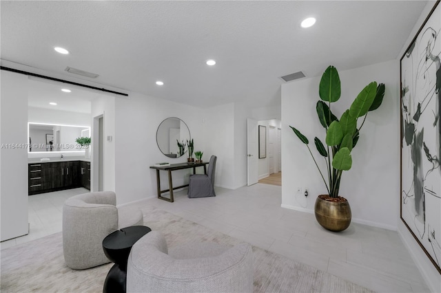 sitting room with recessed lighting, visible vents, and a barn door