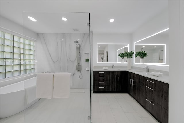 bathroom featuring a freestanding bath, double vanity, a walk in shower, and a sink