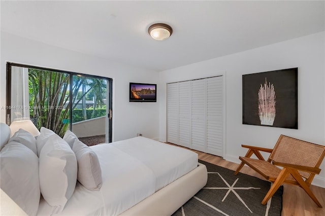 bedroom with a closet, baseboards, and wood finished floors