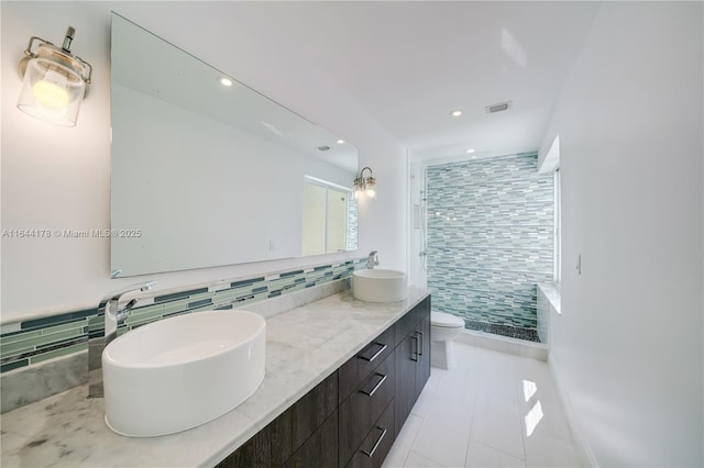 full bath featuring double vanity, a stall shower, toilet, and a sink