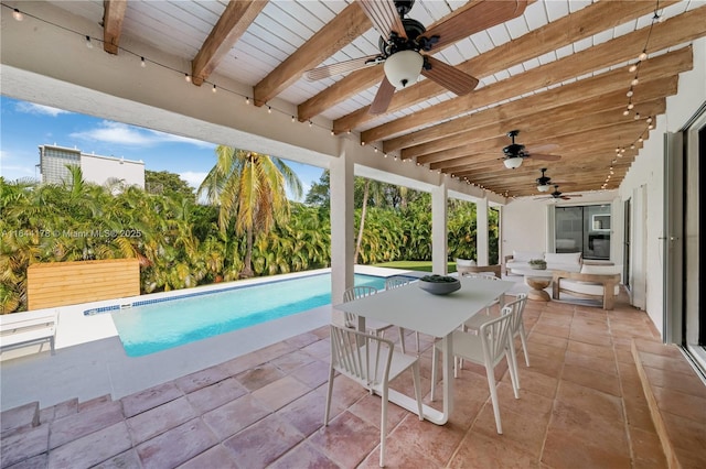 outdoor pool with a patio area, ceiling fan, and outdoor dining area