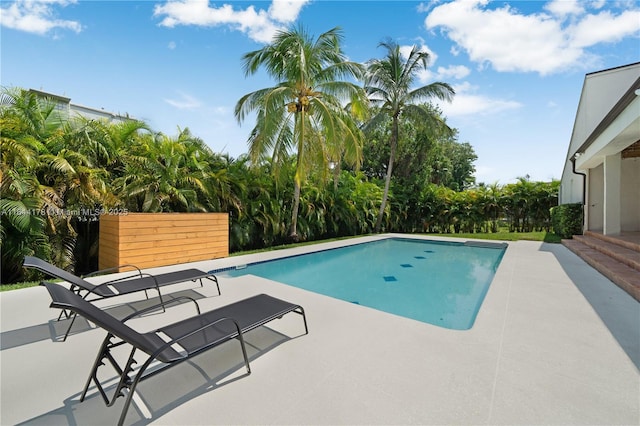 outdoor pool with fence and a patio