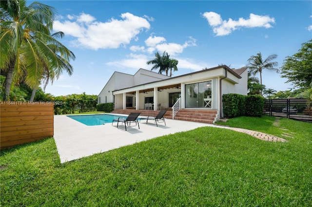 back of house with a fenced in pool, a patio, a lawn, a ceiling fan, and a fenced backyard