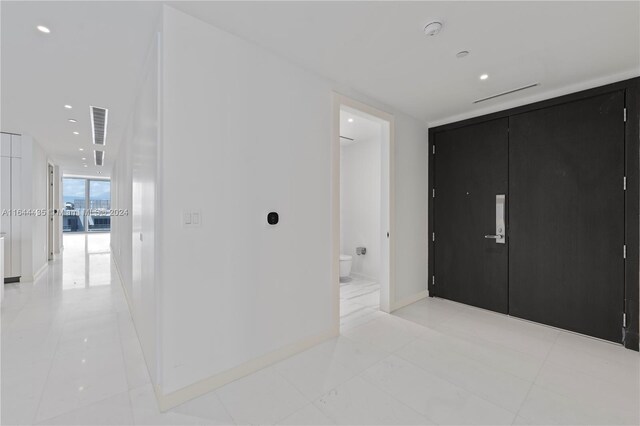 bedroom with ensuite bathroom and a wall of windows