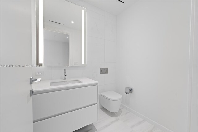 bathroom with tile walls, toilet, and vanity