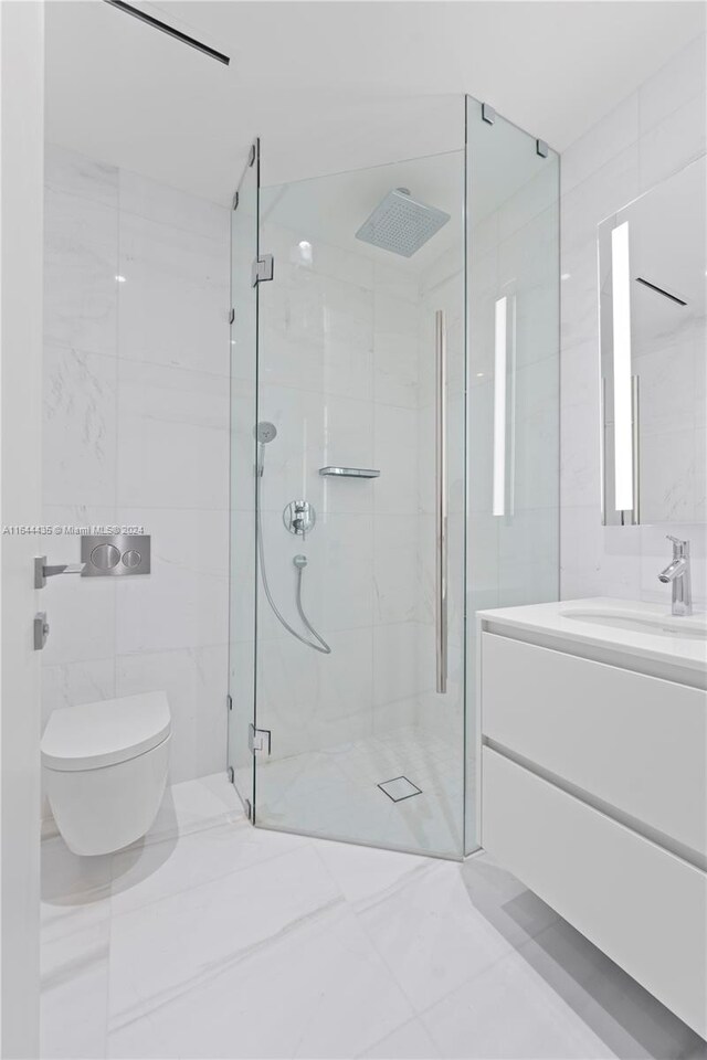 bathroom featuring vanity, an enclosed shower, tile walls, toilet, and tile patterned floors