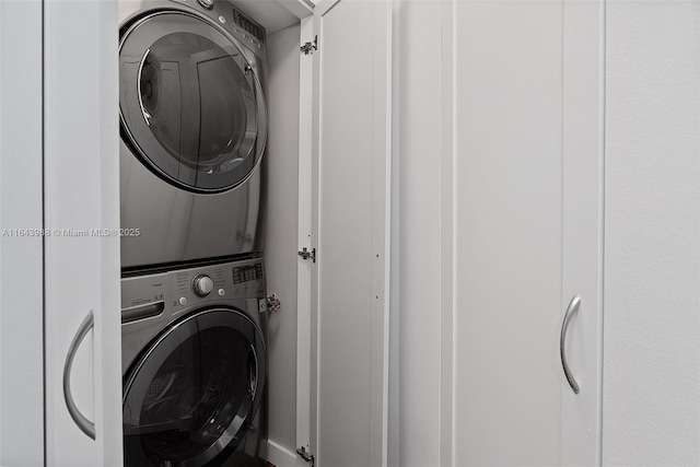 washroom with stacked washing maching and dryer