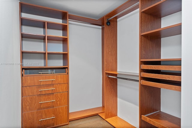 walk in closet with light hardwood / wood-style floors