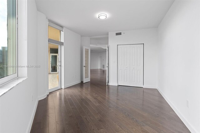 unfurnished bedroom featuring dark wood-type flooring and a closet