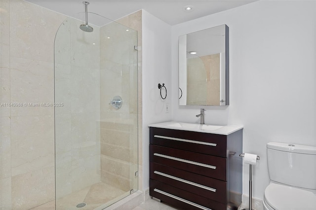 bathroom featuring toilet, vanity, and a shower with shower door