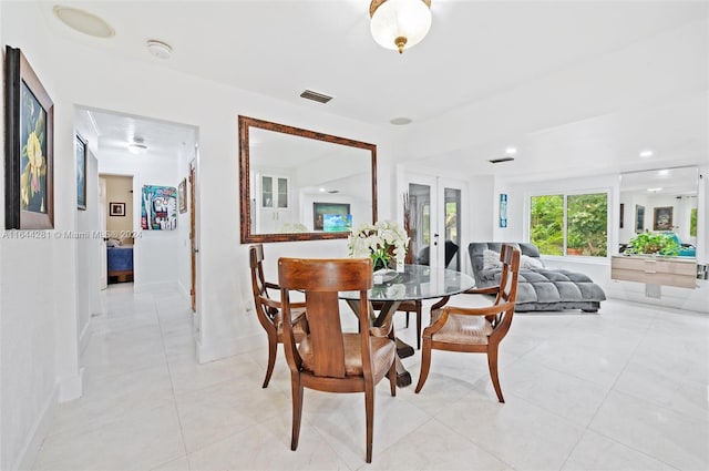 tiled dining room featuring french doors