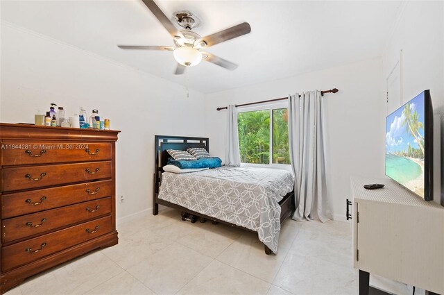 bedroom featuring ceiling fan, light tile patterned floors, and ornamental molding