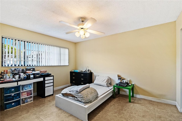 bedroom featuring ceiling fan, a textured ceiling, and light tile patterned floors