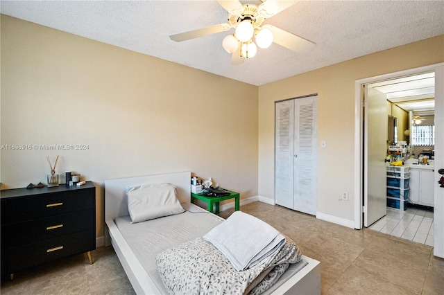 tiled bedroom with a textured ceiling, a closet, and ceiling fan