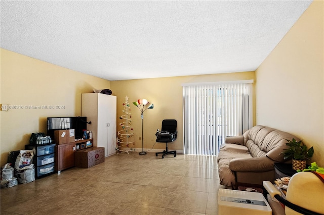 tiled living room featuring a textured ceiling