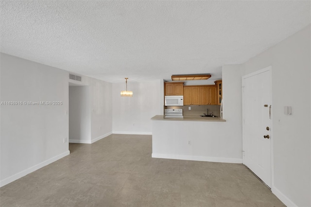 468 NE 206th Ln Unit 105, Miami, FL 33179 - unfurnished living room featuring a textured ceiling, visible vents, baseboards, a sink, and a notable chandelier