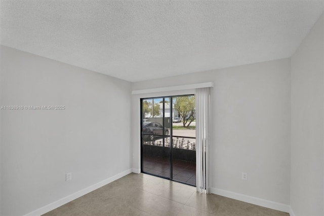 468 NE 206th Ln Unit 105, Miami, FL 33179 - unfurnished room featuring baseboards, tile patterned flooring, and a textured ceiling