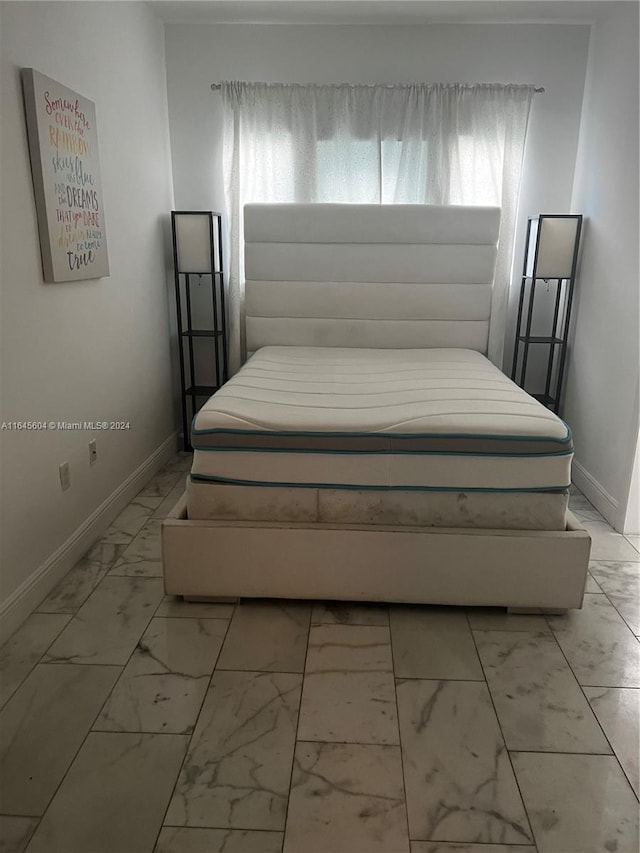 bedroom with multiple windows and light tile patterned floors