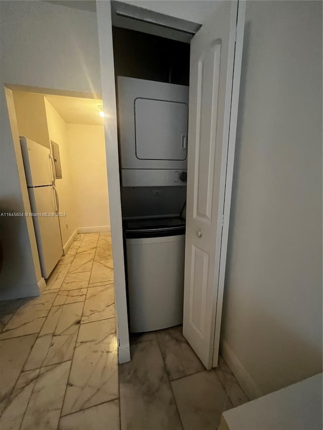 clothes washing area with stacked washer and dryer and light tile patterned floors