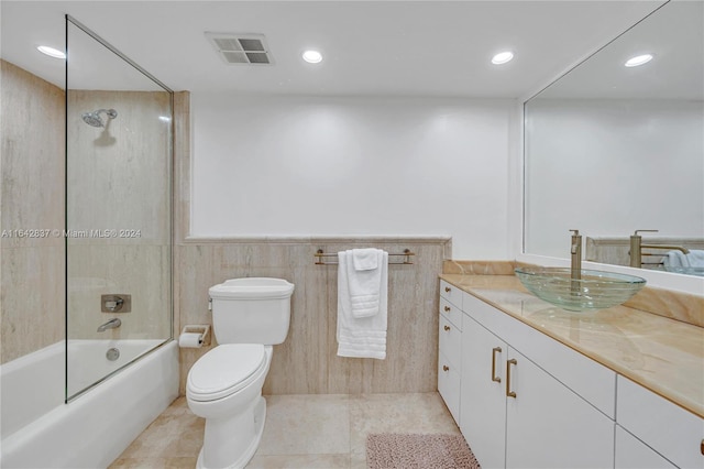 full bathroom with tile patterned flooring, vanity, tiled shower / bath combo, and toilet