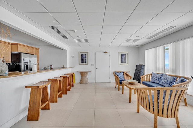 interior space featuring a paneled ceiling and light tile patterned floors